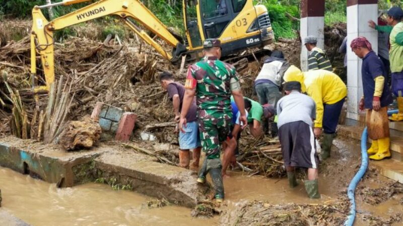 Perugas dan dinas terkait dibantu warga melakukan pembersihan material longsor